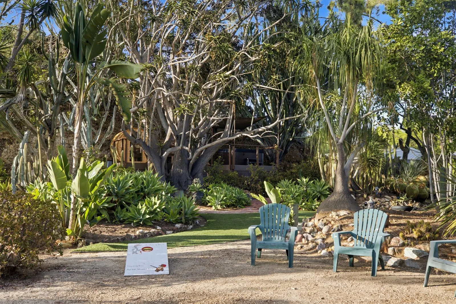 Adirondack chairs in a circle with cornhole boards