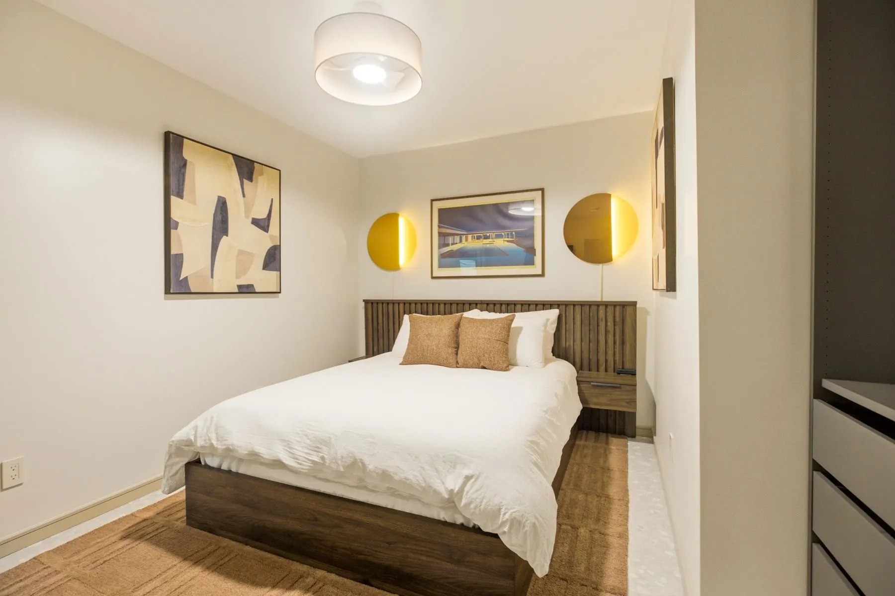 Queen bed with fluted headboard and brass sconces