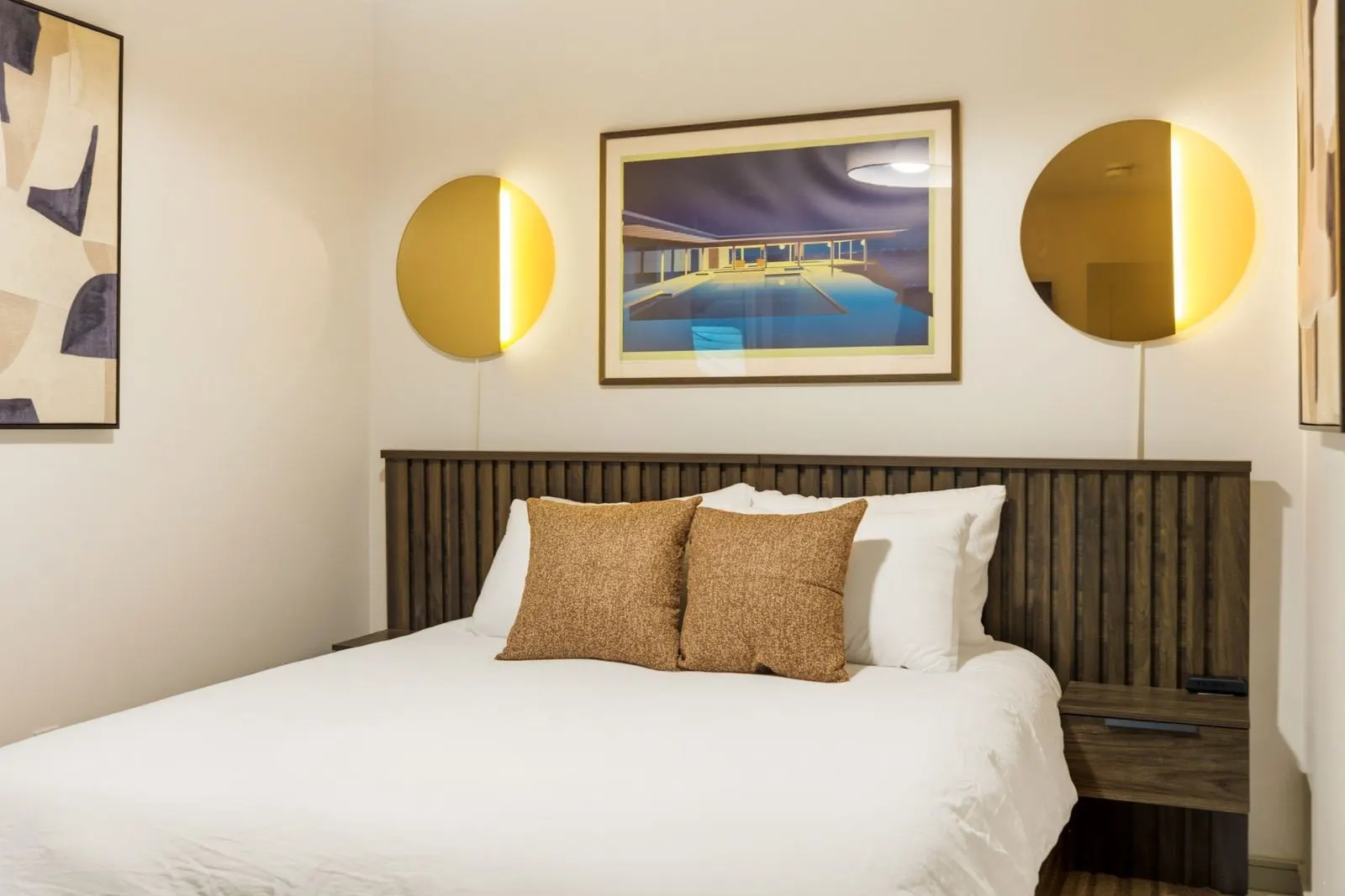 Queen bedroom with round brass wall lights