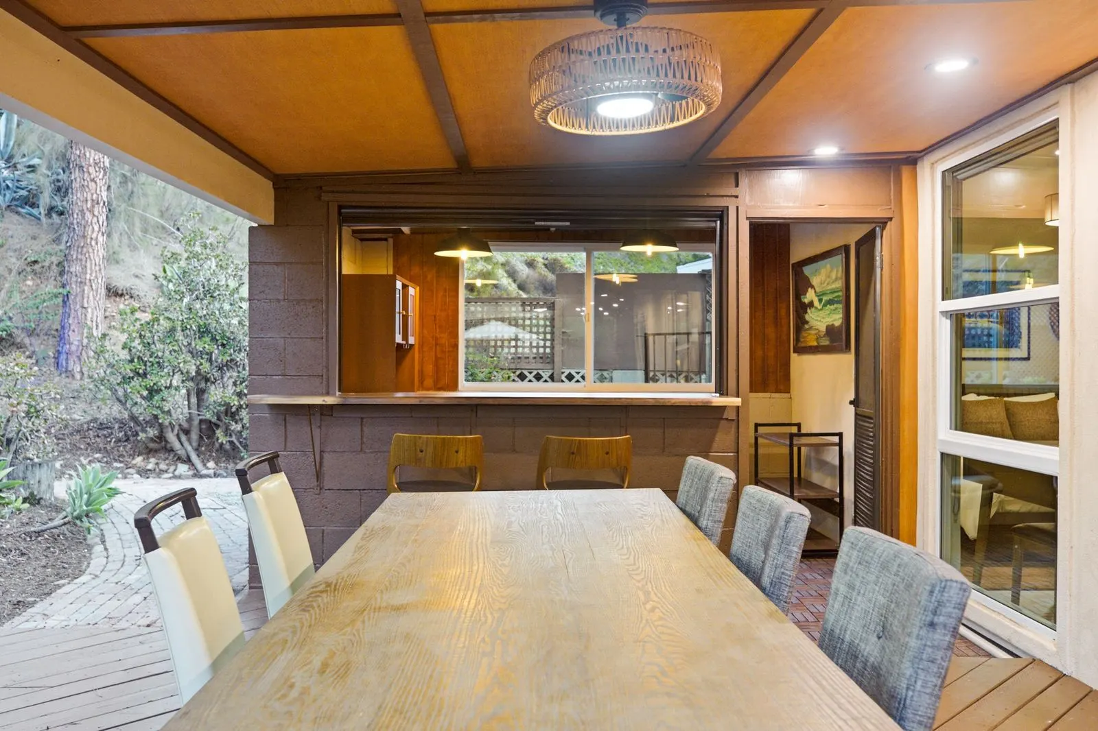 Long wooden dining table under the covered outdoor room